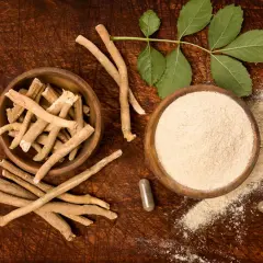 Korzeń i proszek z ashwagandhy, znanej jako adaptogen. Obok kapsułki i liście rośliny.