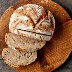 Chleb żytni na zakwasie, pokrojony na desce, to dobry wybór, jeśli zastanawiasz się, jaki chleb ma najmniej kalorii.