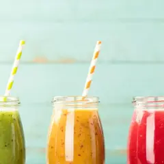 Trzy kolorowe koktajle w słoiczkach, idealne na dietę koktajlową. Zielony, pomarańczowy i czerwony napój z owoców.