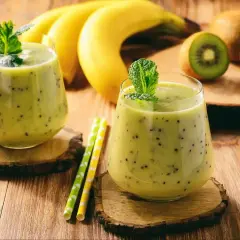 Dwa pyszne koktajle na przytycie z kiwi i bananem, ozdobione miętą. Idealne na zdrowy przyrost masy.