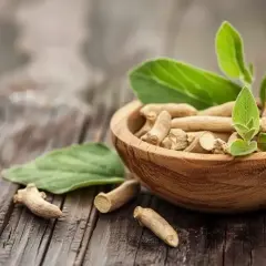 Korzeń ashwagandhy w drewnianej misce, z liśćmi. Naturalne wsparcie dla osób z Hashimoto.