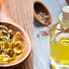 Łyżka z kapsułkami i buteleczka oleju lnianego. Czy tran jest zdrowy? Tak, to cenne źródło kwasów omega-3.