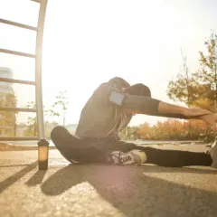 Mężczyzna wykonuje dynamiczny stretching na świeżym powietrzu, przygotowując się do treningu.