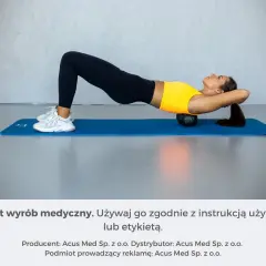 Kobieta wykonuje ćwiczenia na garb wdowi, leżąc na macie z wałkiem pod plecami.
