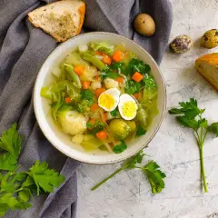 Lekka zupa warzywna z jajkiem, idealna jako jeden z przepisów na zupy w diecie trzustkowej. Podana z pieczywem i natką pietruszki.
