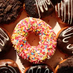 Kolorowe pączki z posypką i czekoladowe z polewą, idealne na cheat day.