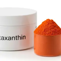 Słoiczek z napisem "Astaxanthin" i miarka pełna pomarańczowego proszku. Poznaj astaksantyna działanie!