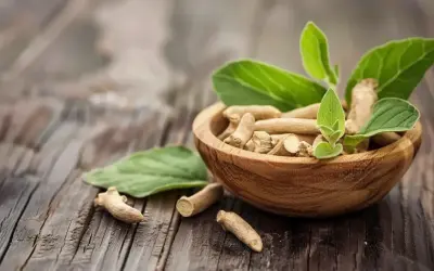 Korzeń ashwagandhy w drewnianej misce, z liśćmi. Naturalne wsparcie dla osób z Hashimoto.