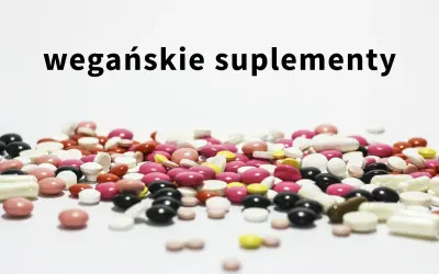 Kolorowe tabletki i kapsułki, w tym suplementacja dla wegan, rozsypane na białym tle.