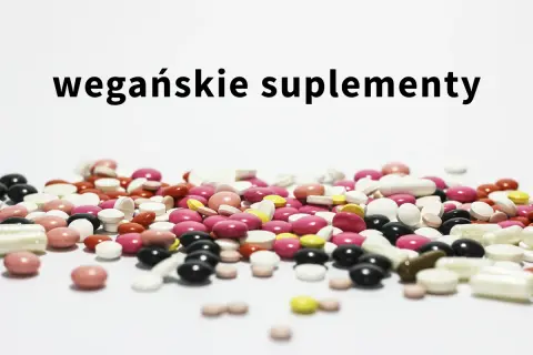 Kolorowe tabletki i kapsułki, w tym suplementacja dla wegan, rozsypane na białym tle.