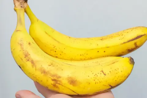Dwa żółte banany z brązowymi plamkami, idealne na zdrową przekąskę. Zastanawiasz się, ile bananów dziennie jest dla Ciebie najlepsze?