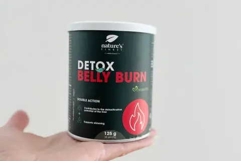 Puszka suplementu Detox Belly Burn w dłoni. Produkt wspiera odchudzanie i detoksykację wątroby.
