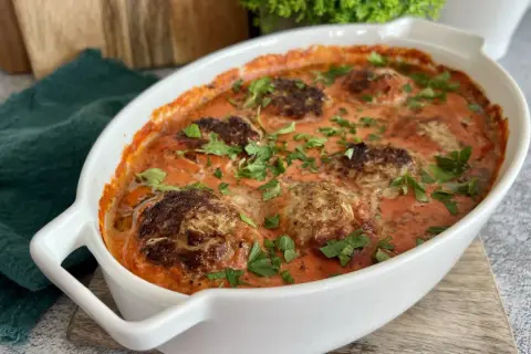 Pyszne klopsiki w sosie pomidorowym, idealne na obiad low carb. Posypane świeżą natką pietruszki.