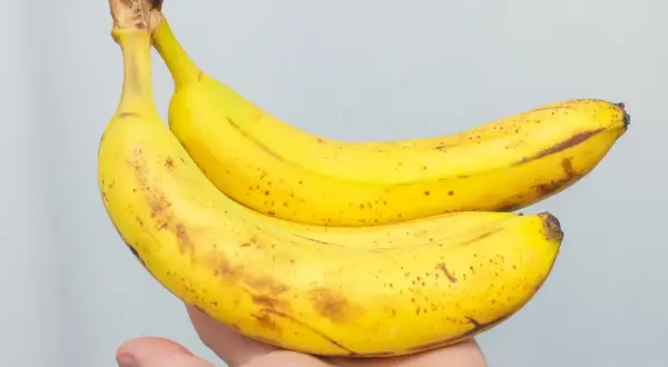 Dwa żółte banany z brązowymi plamkami, idealne na zdrową przekąskę. Zastanawiasz się, ile bananów dziennie jest dla Ciebie najlepsze?