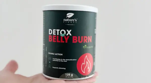 Puszka suplementu Detox Belly Burn w dłoni. Produkt wspiera odchudzanie i detoksykację wątroby.