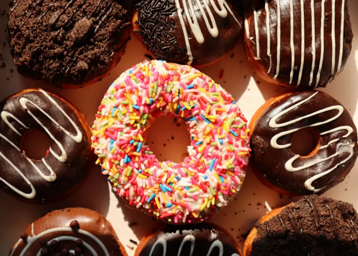 Kolorowe pączki z posypką i czekoladowe z polewą, idealne na cheat day.