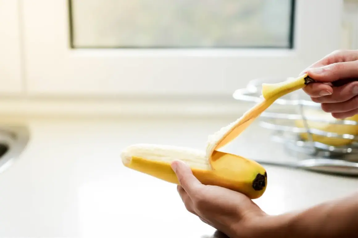 Dłoń obiera banana. Pamiętaj, z czym nie łączyć potasu, by uniknąć problemów zdrowotnych.