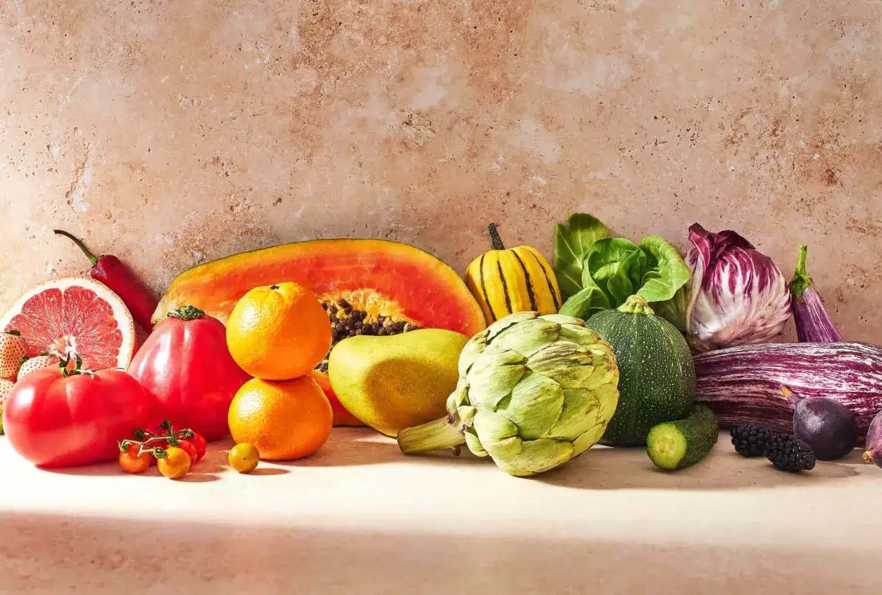 Kolorowy wybór owoców i warzyw: papaja, pomarańcze, pomidor, karczoch, cukinia, bakłażan, cykoria, ogórek, jeżyny. Idealne składniki na zdrową dietę warzywną.