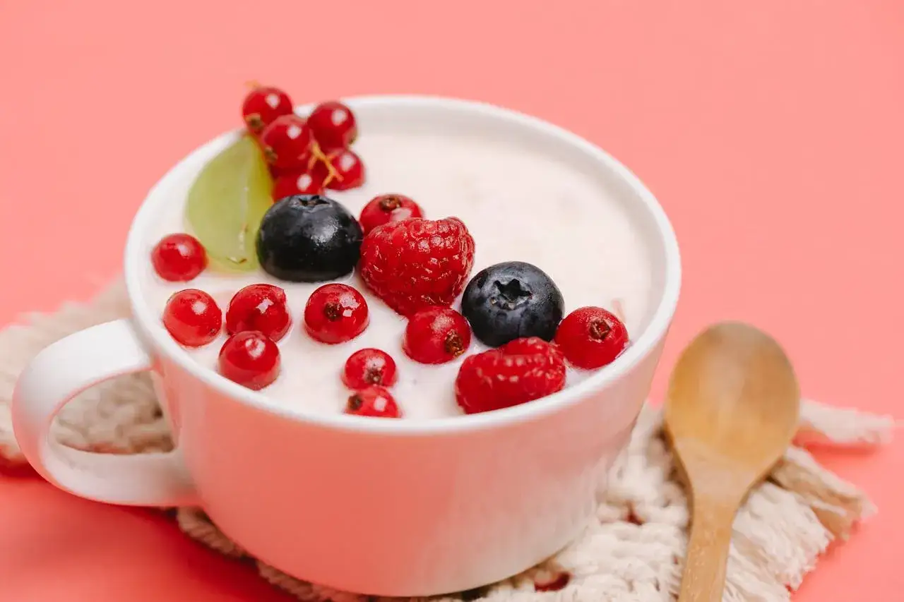 Pyszny jogurt z malinami, borówkami i porzeczkami. Idealny na śniadanie, ale do której godziny można jeść owoce?