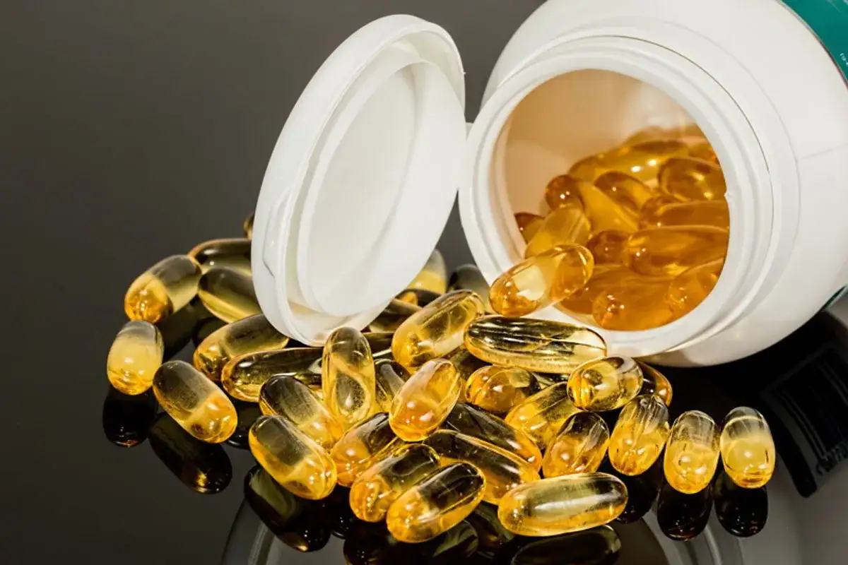 Kapsułki omega 3 rozsypane z otwartego pojemnika. Uważaj na przedawkowanie omega 3, bo może być niebezpieczne.
