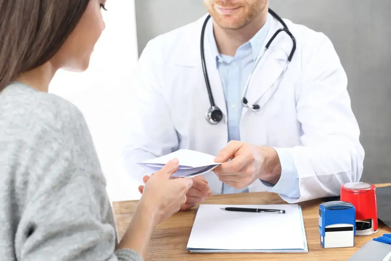 Lekarz przekazuje pacjentce dokumenty. Może to być skierowanie na badania, które pomogą zdiagnozować szybkie przybieranie na wadze.