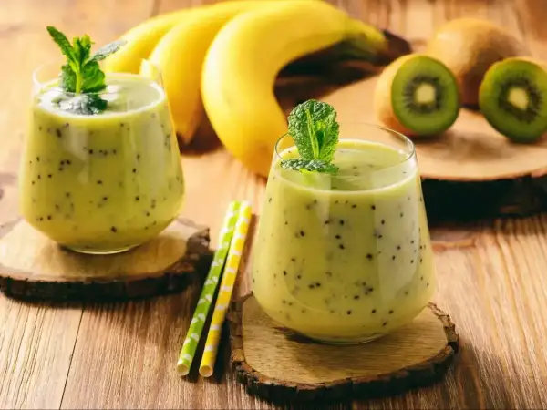 Dwa pyszne koktajle na przytycie z kiwi i bananem, ozdobione miętą. Idealne na zdrowy przyrost masy.