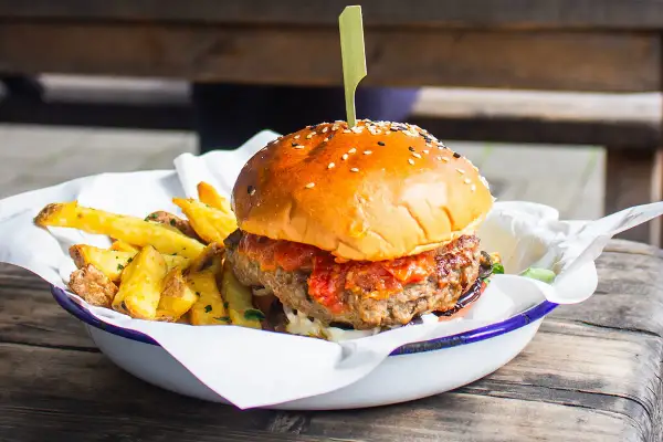 Soczysty burger z frytkami, idealne kaloryczne przekąski na masę.