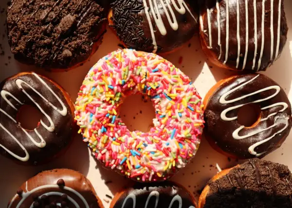 Kolorowe pączki z posypką i czekoladowe z polewą, idealne na cheat day.